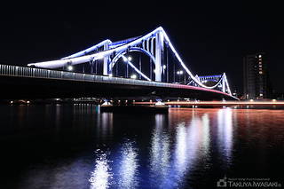 ライトアップされた清洲橋と屋形船の光跡を望む
