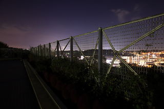 フェンス越しにランドマークタワー方面の夜景を望む