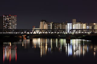 東海道本線を走る電車の光跡と川崎競馬場方面の夜景