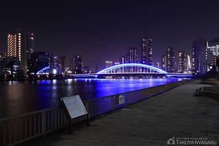 隅田川テラスの案内版と永代橋のライトアップ